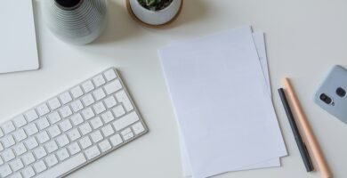 white printer paper beside white apple keyboard